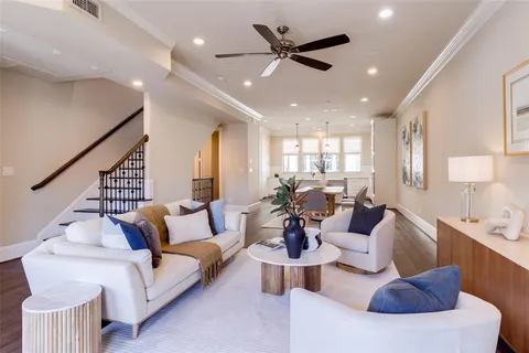 a living room with furniture kitchen view and a large window
