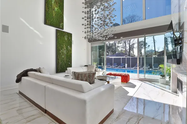 a living room with furniture a rug and wall paintings