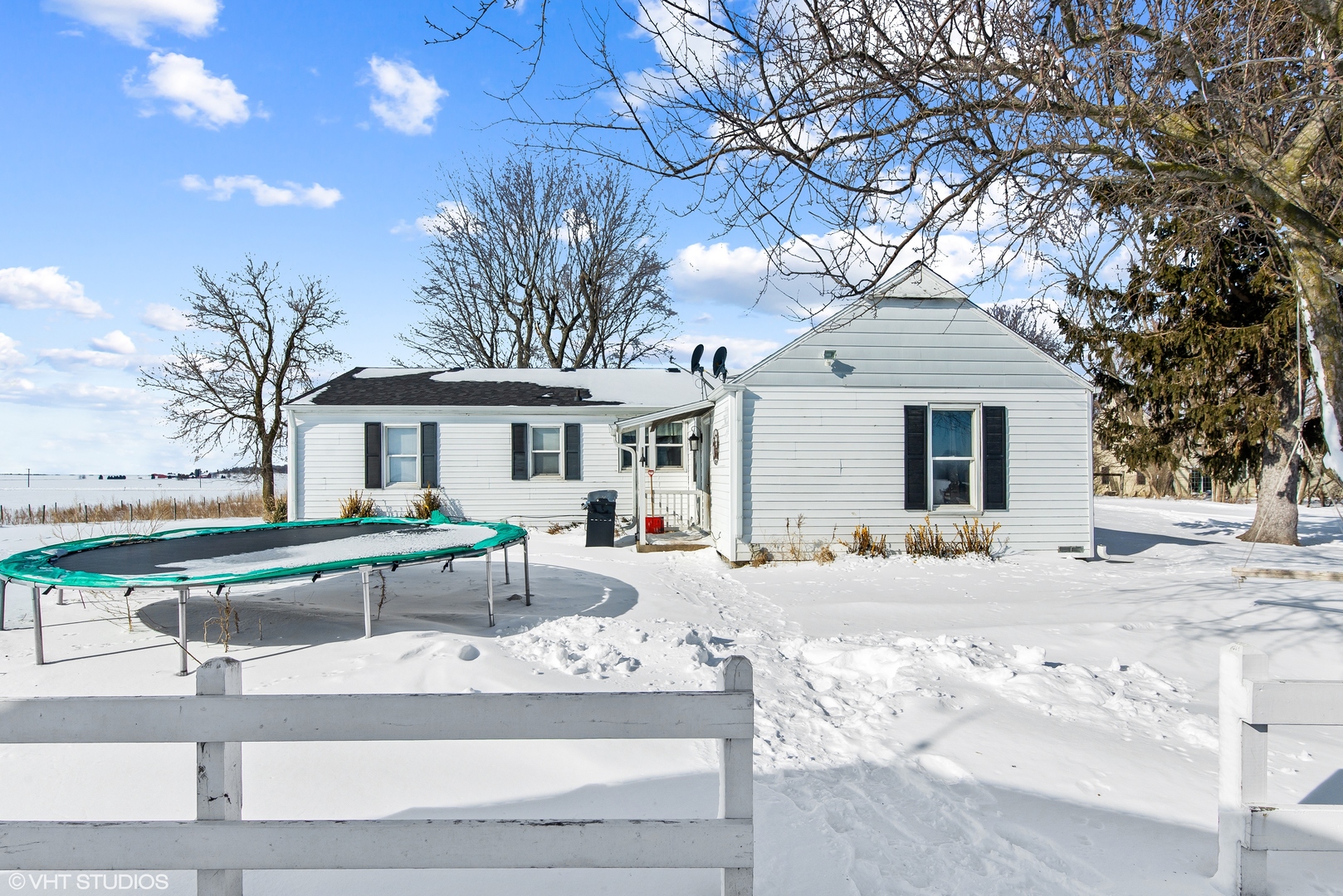 3559 Carlson Road Garden Prairie, IL 61038 - Photo 14 of 17 a view of a white house with a couches and table and chairs under an umbrella
