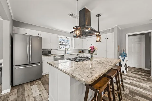 a kitchen with kitchen island granite countertop a stove oven and a refrigerator