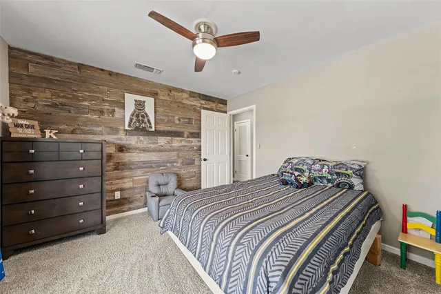 a spacious bedroom with a bed and a dresser