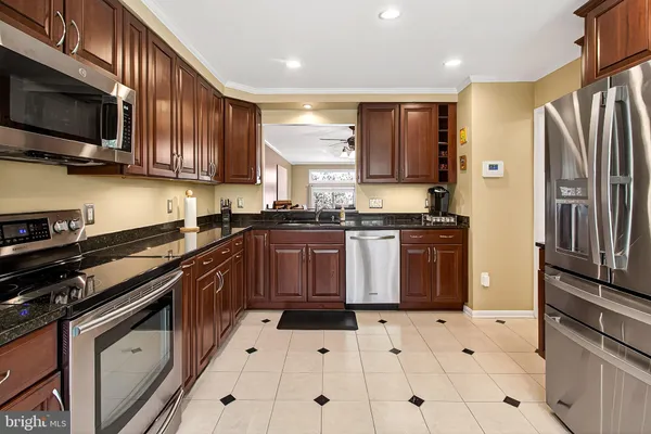 a kitchen with stainless steel appliances granite countertop a refrigerator and a sink