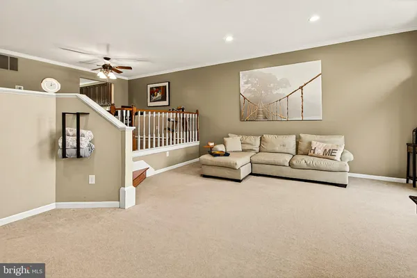 a living room with furniture a flat screen tv and a large window