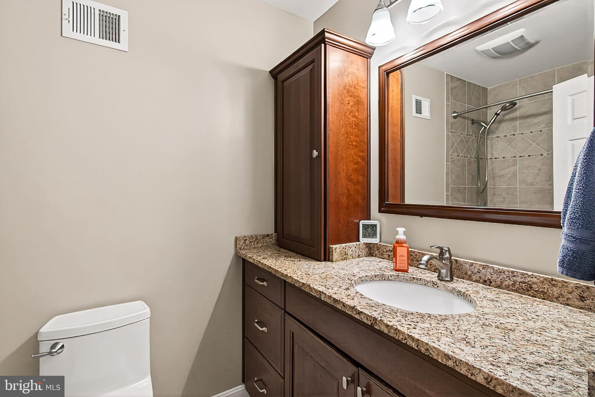 7923 Valleyfield Drive Springfield, VA 22153 - Photo 35 of 51 a bathroom with a granite countertop sink and a mirror