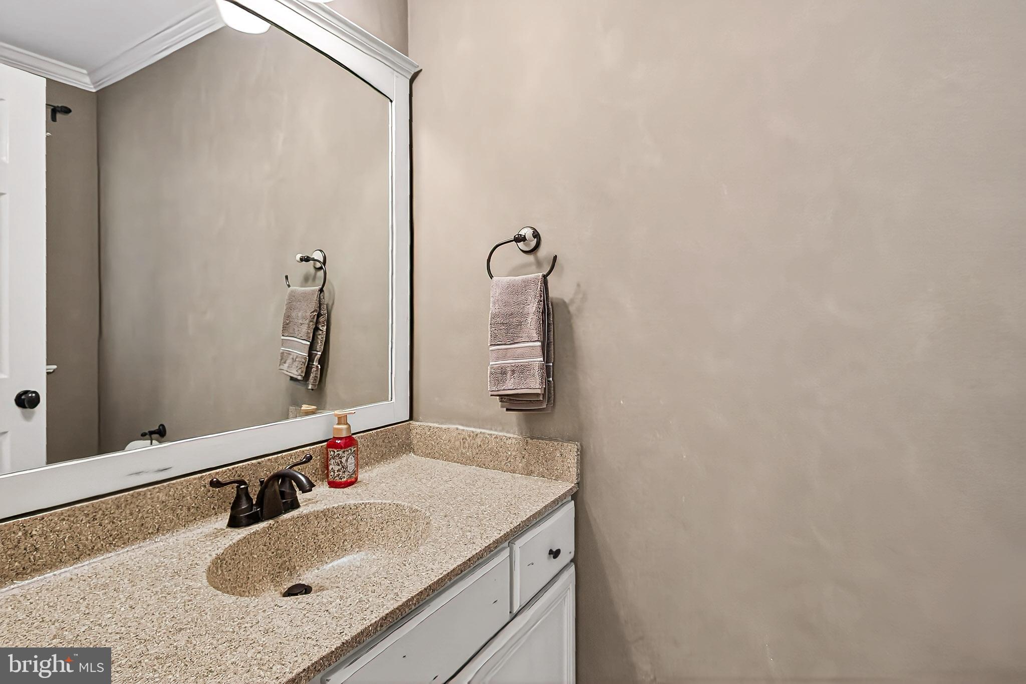7923 Valleyfield Drive Springfield, VA 22153 - Photo 6 of 51 a bathroom with a granite countertop sink and a mirror