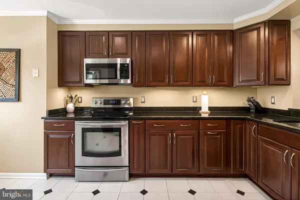 a kitchen with stainless steel appliances granite countertop a stove sink and cabinets