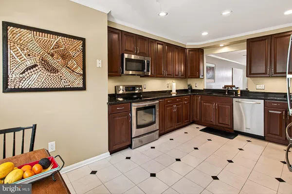 a kitchen with stainless steel appliances granite countertop a stove top oven a sink dishwasher a refrigerator and cabinets