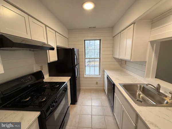 a kitchen with a stove a refrigerator and a sink
