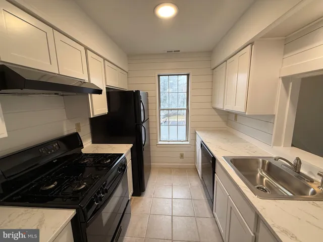 a kitchen with a stove a refrigerator and a sink