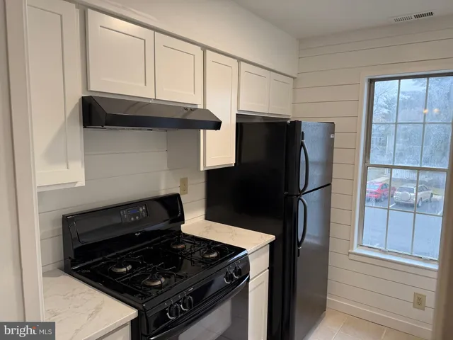 a kitchen with granite countertop a refrigerator and a stove