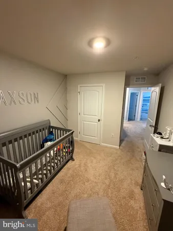 a bedroom with a bed and lamp on desk