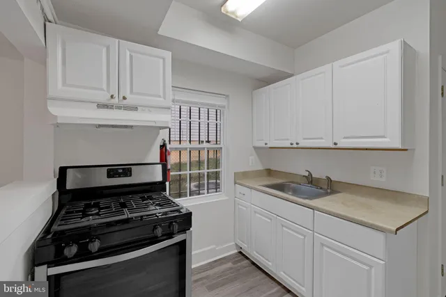 a kitchen with white cabinets and appliances