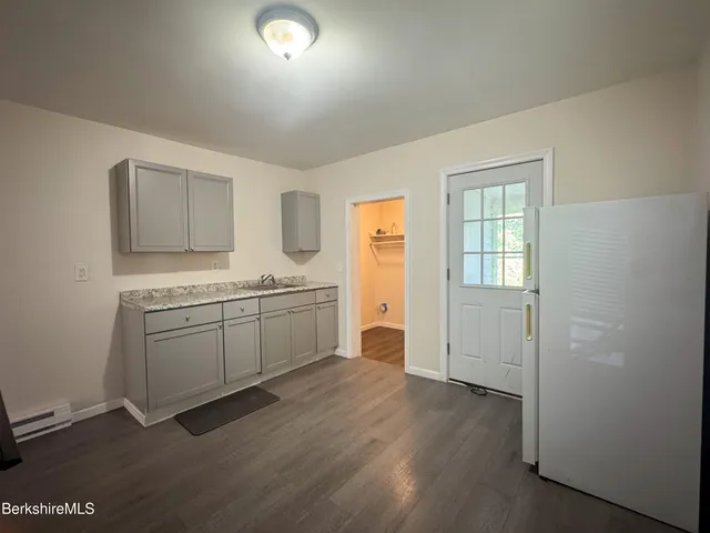 a room with a sink cabinets and wooden floor