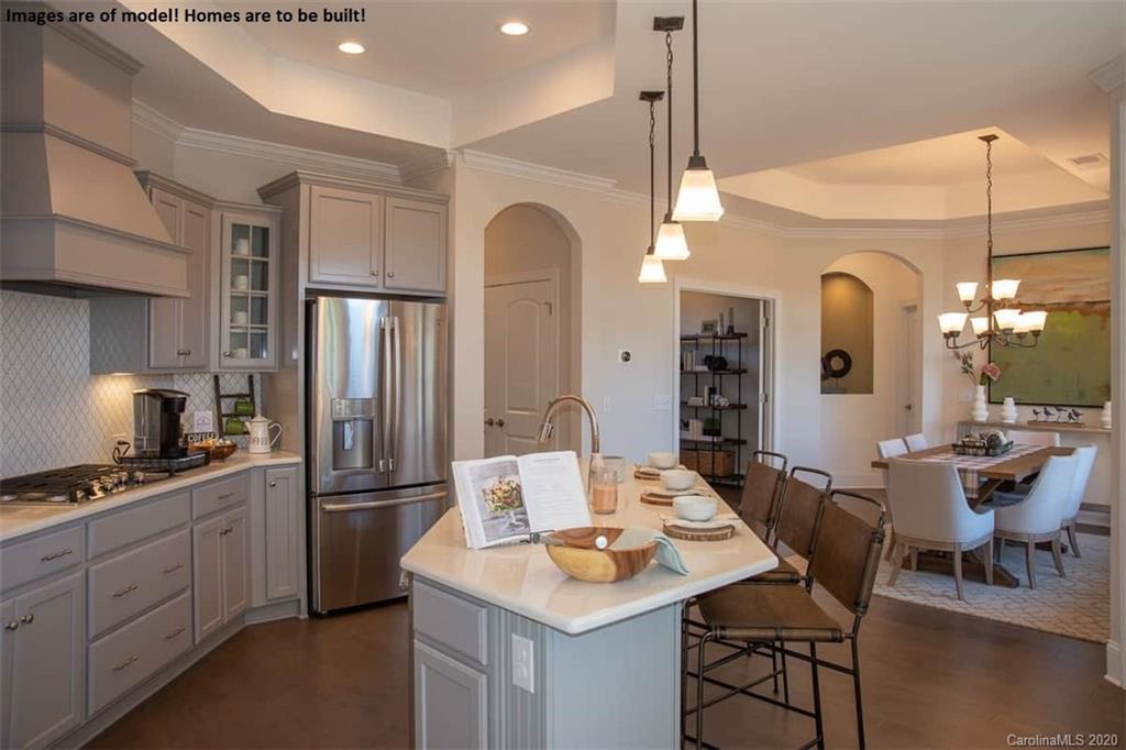 2069 New Style Way, Unit 32 Tega Cay, SC 29708 - Photo 17 of 30 a kitchen with stainless steel appliances kitchen island granite countertop a dining table chairs and a refrigerator