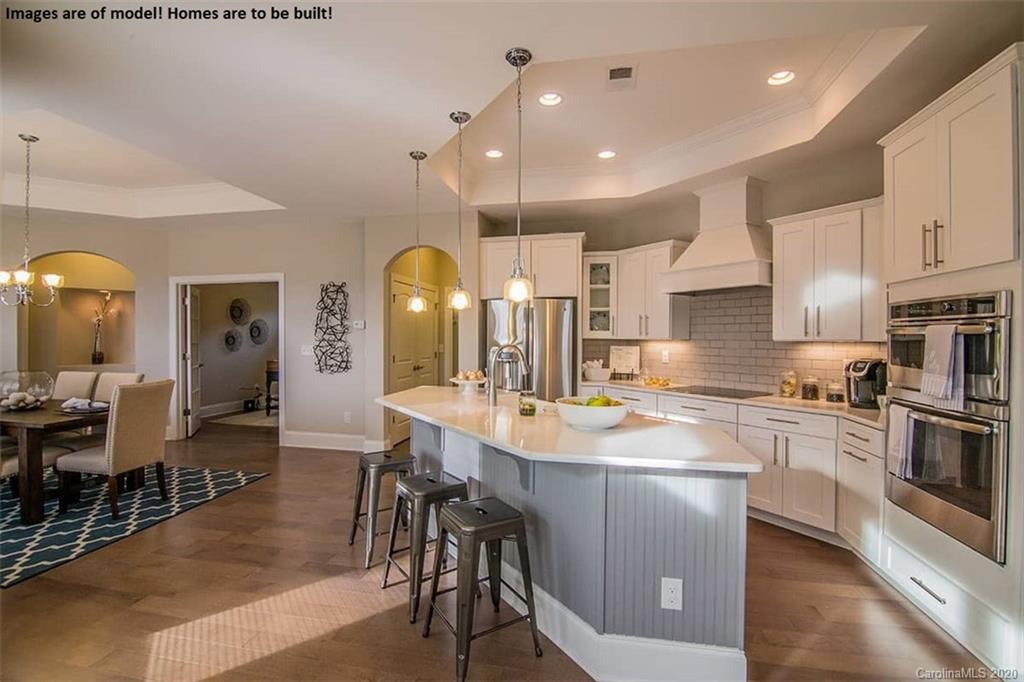 2069 New Style Way, Unit 32 Tega Cay, SC 29708 - Photo 24 of 30 a large kitchen with cabinets chairs and wooden floor