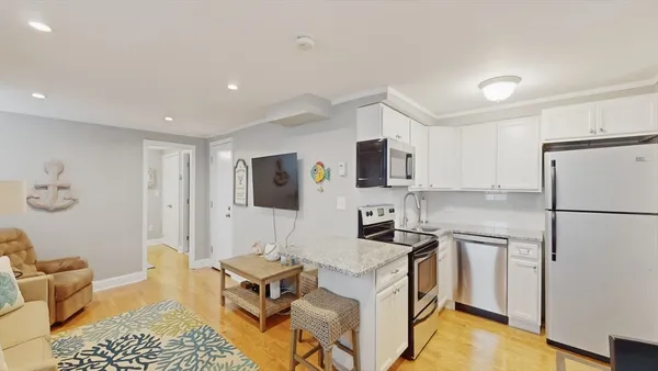 a kitchen with a refrigerator a stove top oven a sink dishwasher and white cabinets with wooden floor