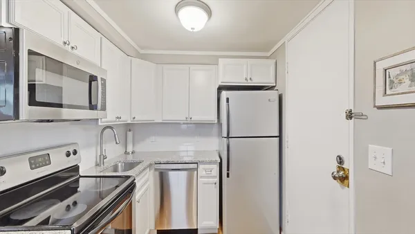 a kitchen with a refrigerator sink stove and cabinets
