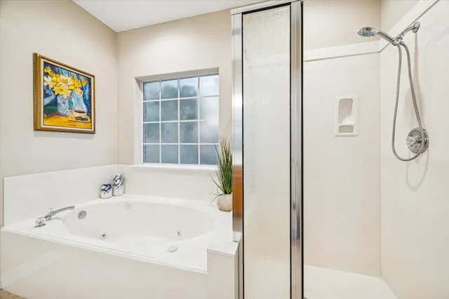 a spacious bathroom with a tub sink and mirror