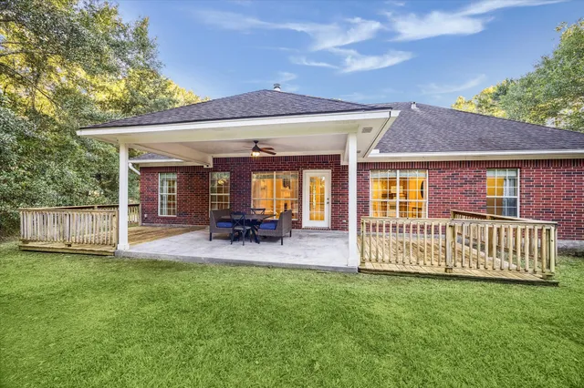 a view of a patio with a table chairs and a yard