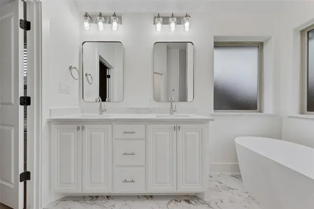 a bathroom with double vanity sinks a toilet a mirror and vanity