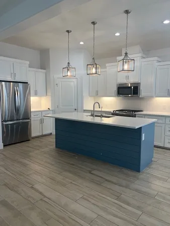 a kitchen with granite countertop a sink and refrigerator