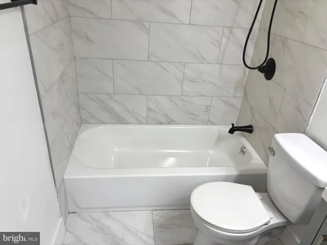 a bathroom with a toilet and a bath tub