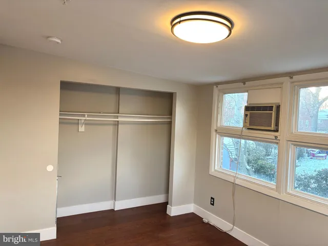 a view of a room with a large window and wooden floor