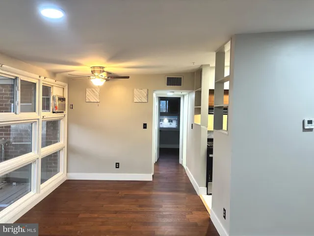 a view of a hallway with wooden floor and entryway