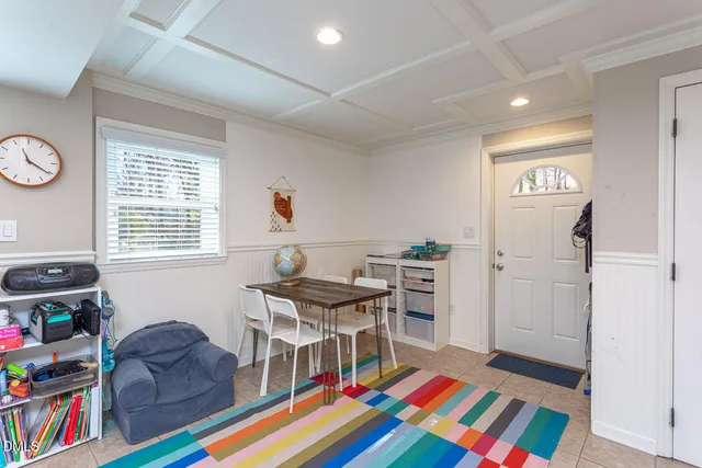 a living room with furniture and a baby crib