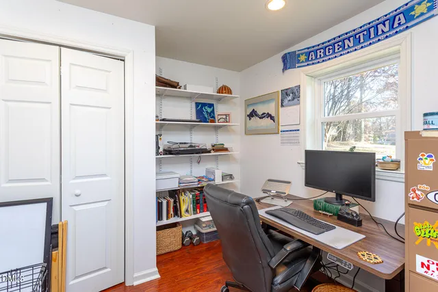 a view of a workspace with furniture and a window