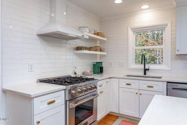 a kitchen with cabinets a stove a sink and a window