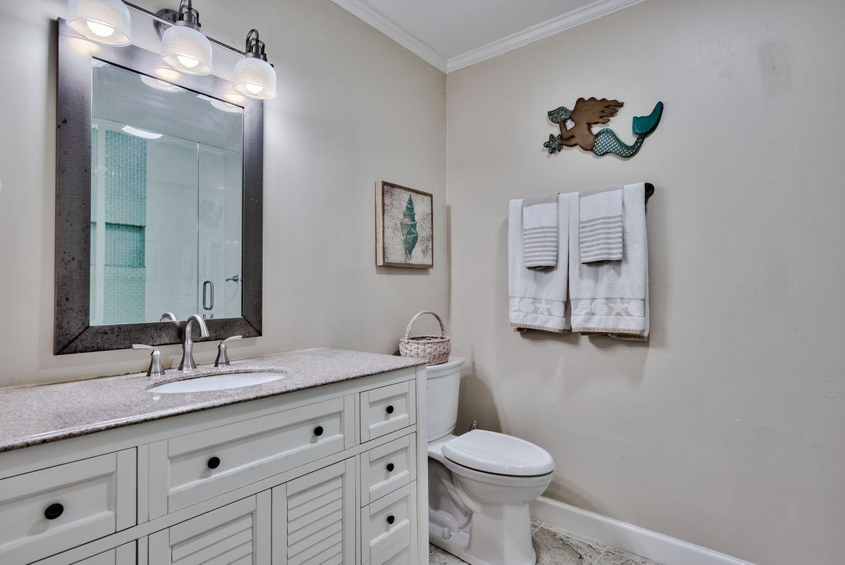 487 Blue Mountain Road Santa Rosa Beach, FL 32459 - Photo 13 of 32 a bathroom with a toilet a sink and mirror
