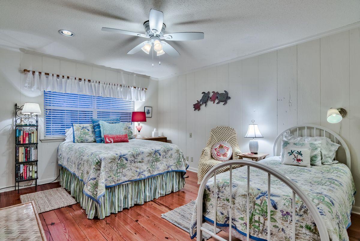 487 Blue Mountain Road Santa Rosa Beach, FL 32459 - Photo 20 of 32 a bedroom with a bed and a chandelier