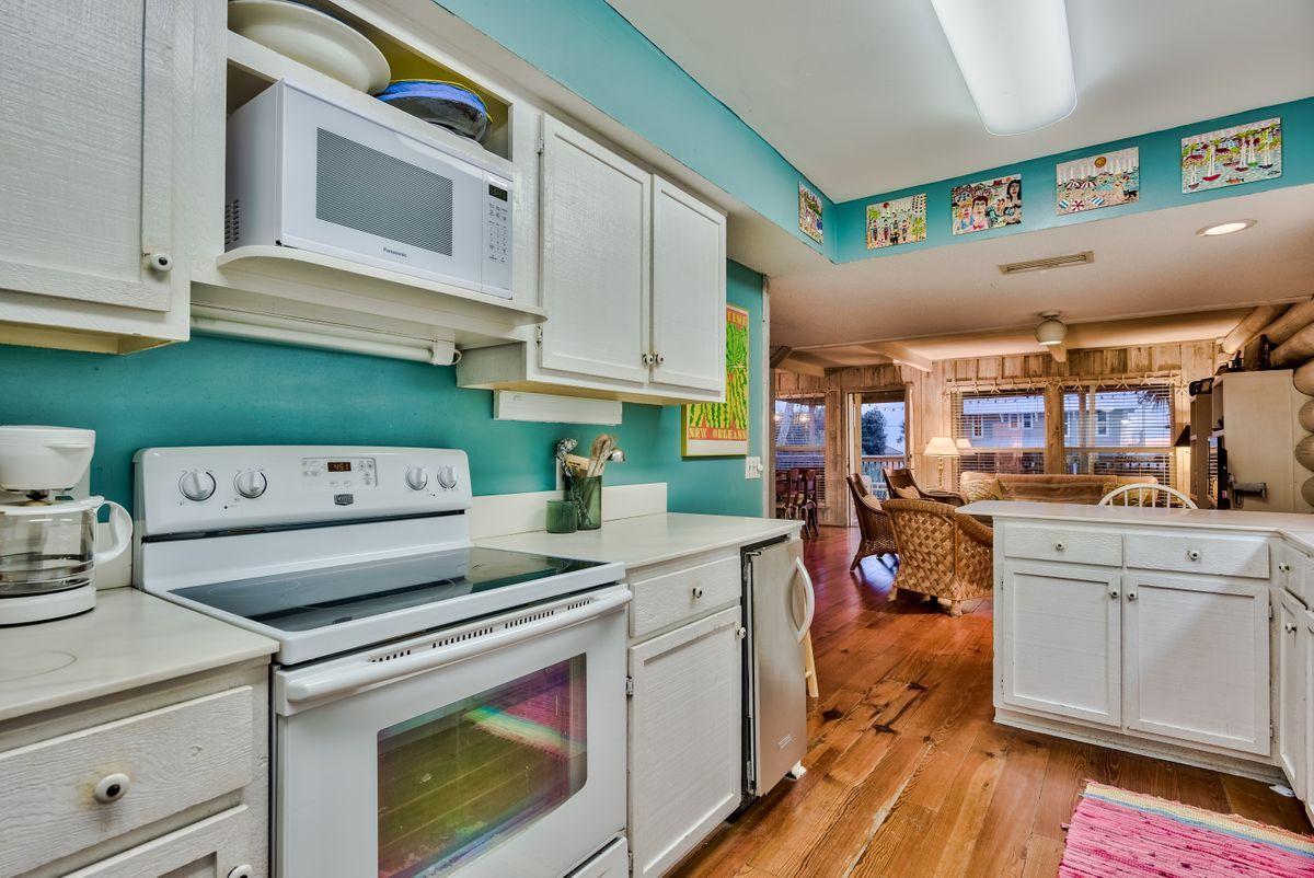 487 Blue Mountain Road Santa Rosa Beach, FL 32459 - Photo 24 of 32 a kitchen with a stove cabinets and wooden floor