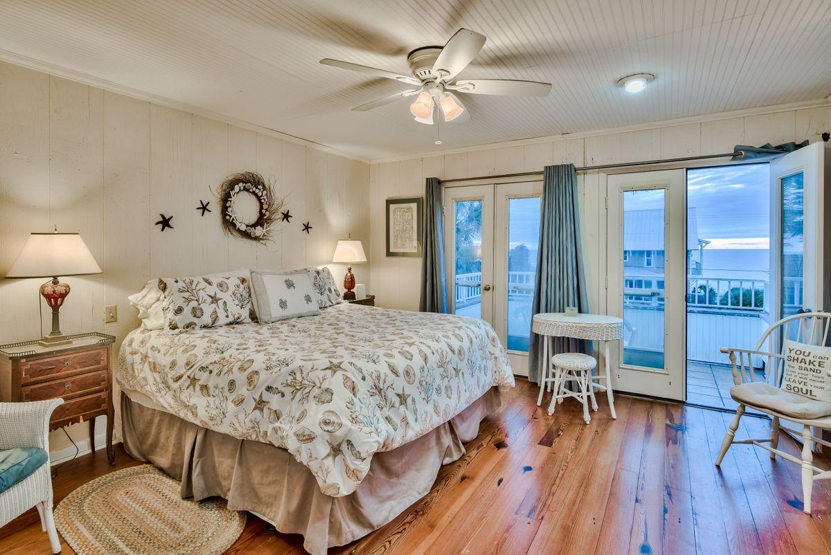 487 Blue Mountain Road Santa Rosa Beach, FL 32459 - Photo 8 of 32 a bedroom with a bed a desk and chair with wooden floor