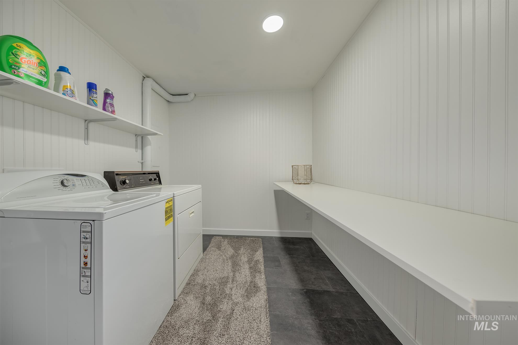 748 Pringle Road Weiser, ID 83672 - Photo 30 of 47 Laundry room featuring beadboard paneling, built-in shelving, and dark-toned flooring