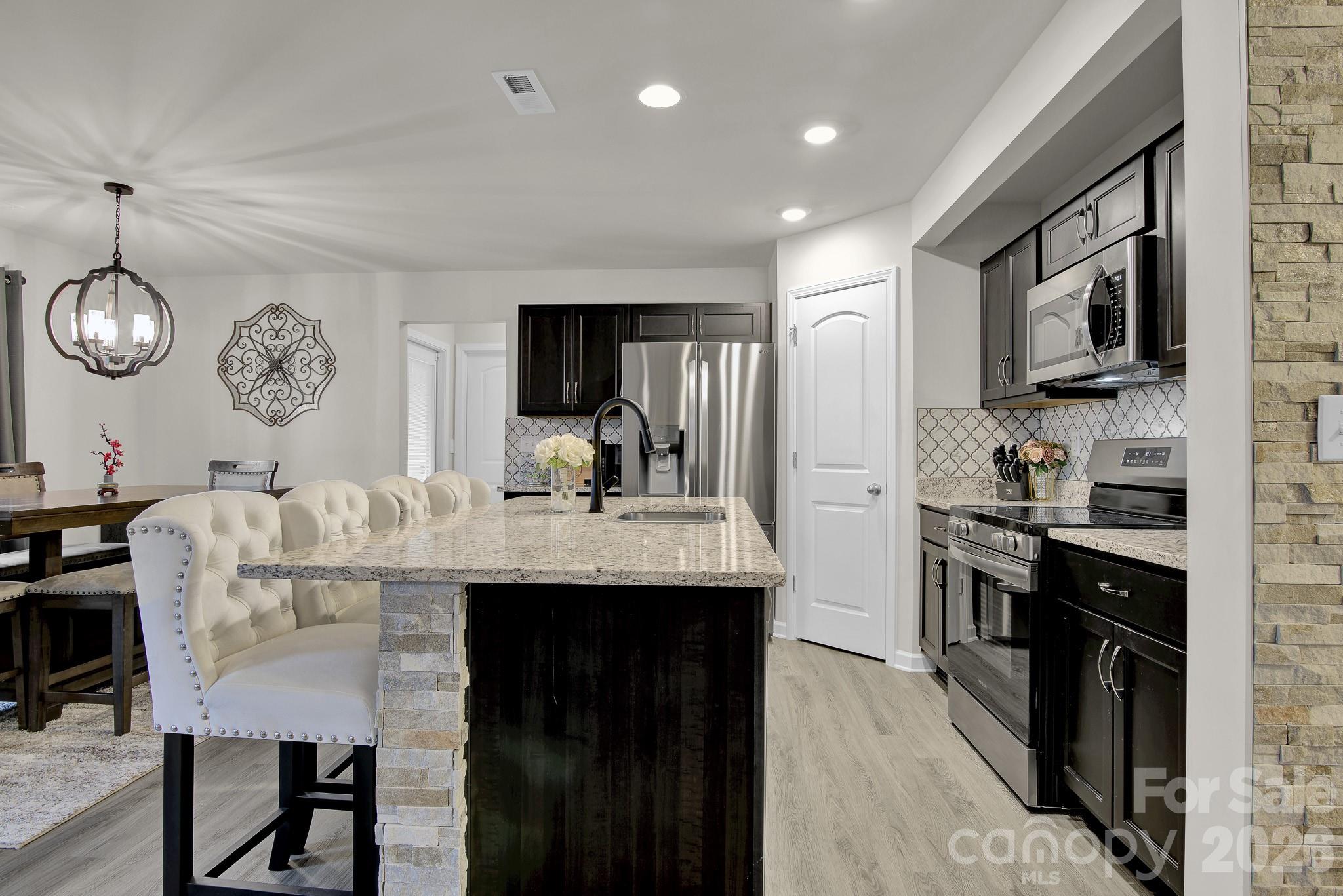 865 Old Linwood Road Lexington, NC 27292 - Photo 11 of 44 a kitchen with cabinets a sink stainless steel appliances and dining table