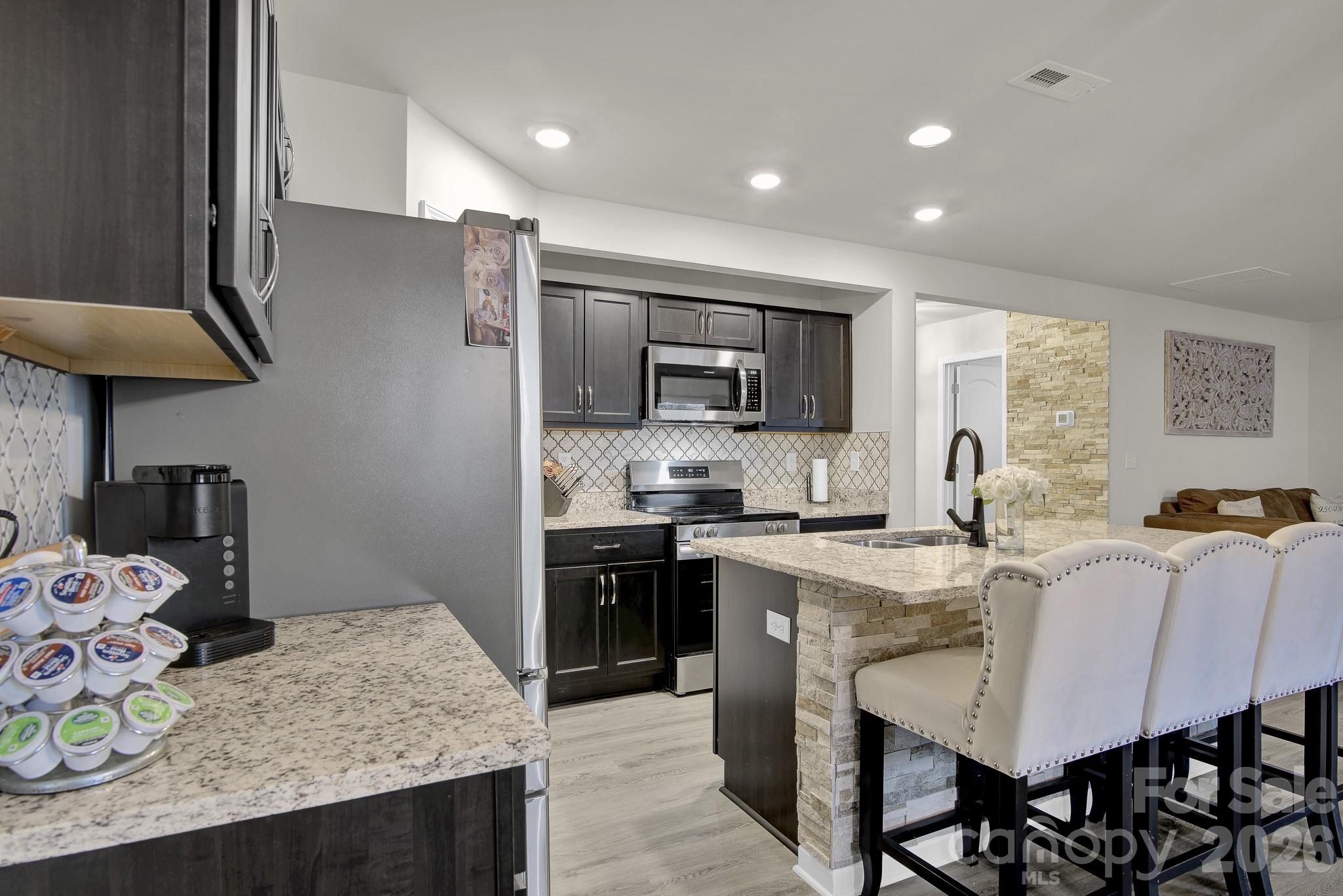 865 Old Linwood Road Lexington, NC 27292 - Photo 14 of 44 a kitchen with granite countertop cabinets stainless steel appliances and dining table
