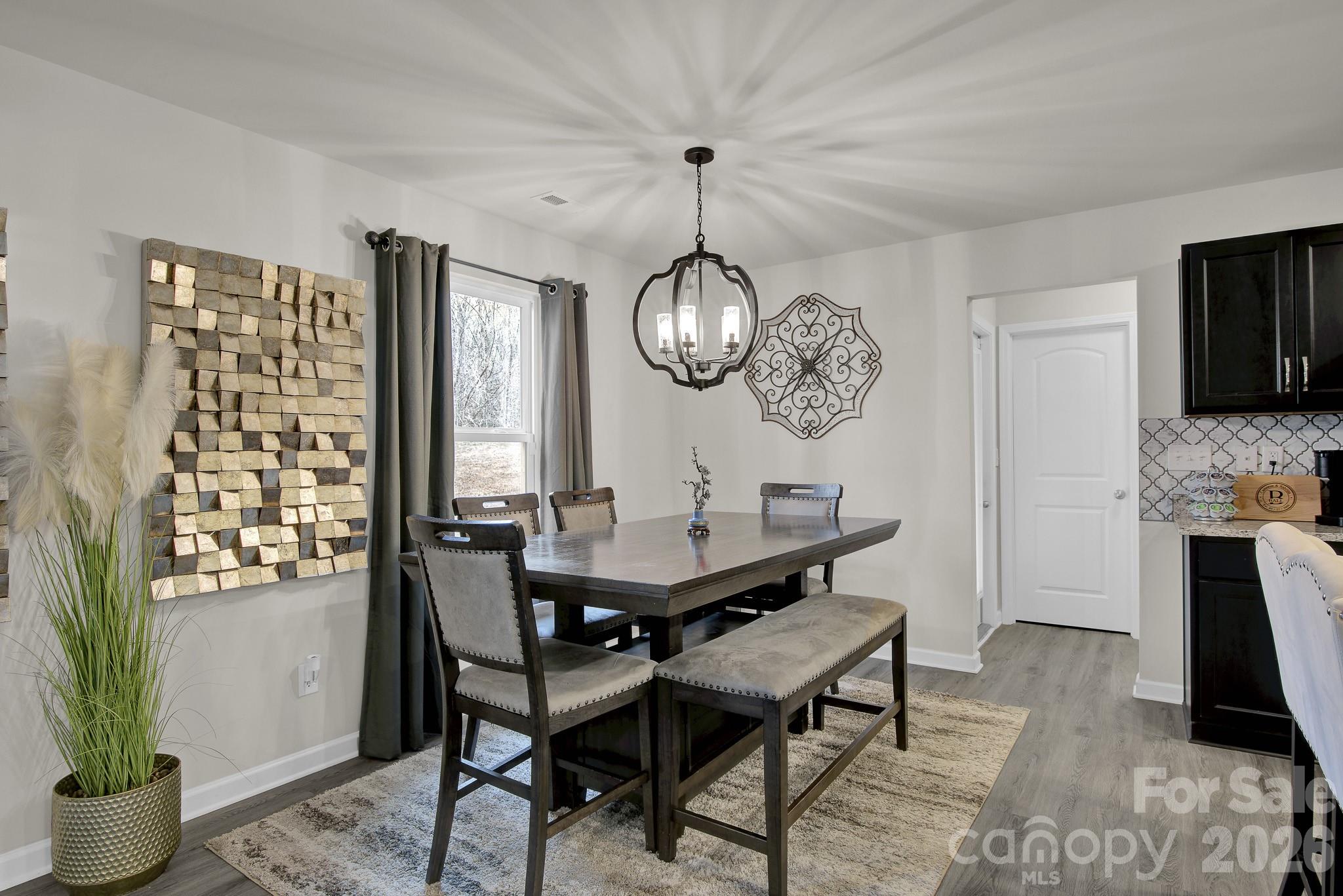 865 Old Linwood Road Lexington, NC 27292 - Photo 21 of 44 a dining room with wooden floor a chandelier a wooden table and chairs