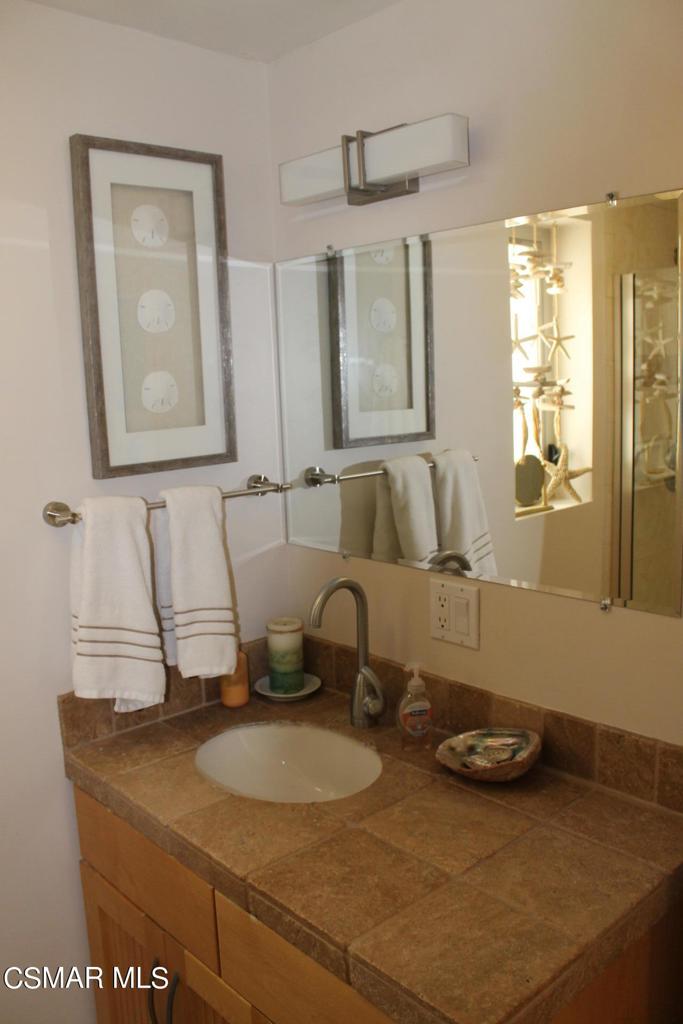 369 Cahuenga Drive Oxnard, CA 93035 - Photo 19 of 36 a bathroom with a granite countertop sink and a mirror