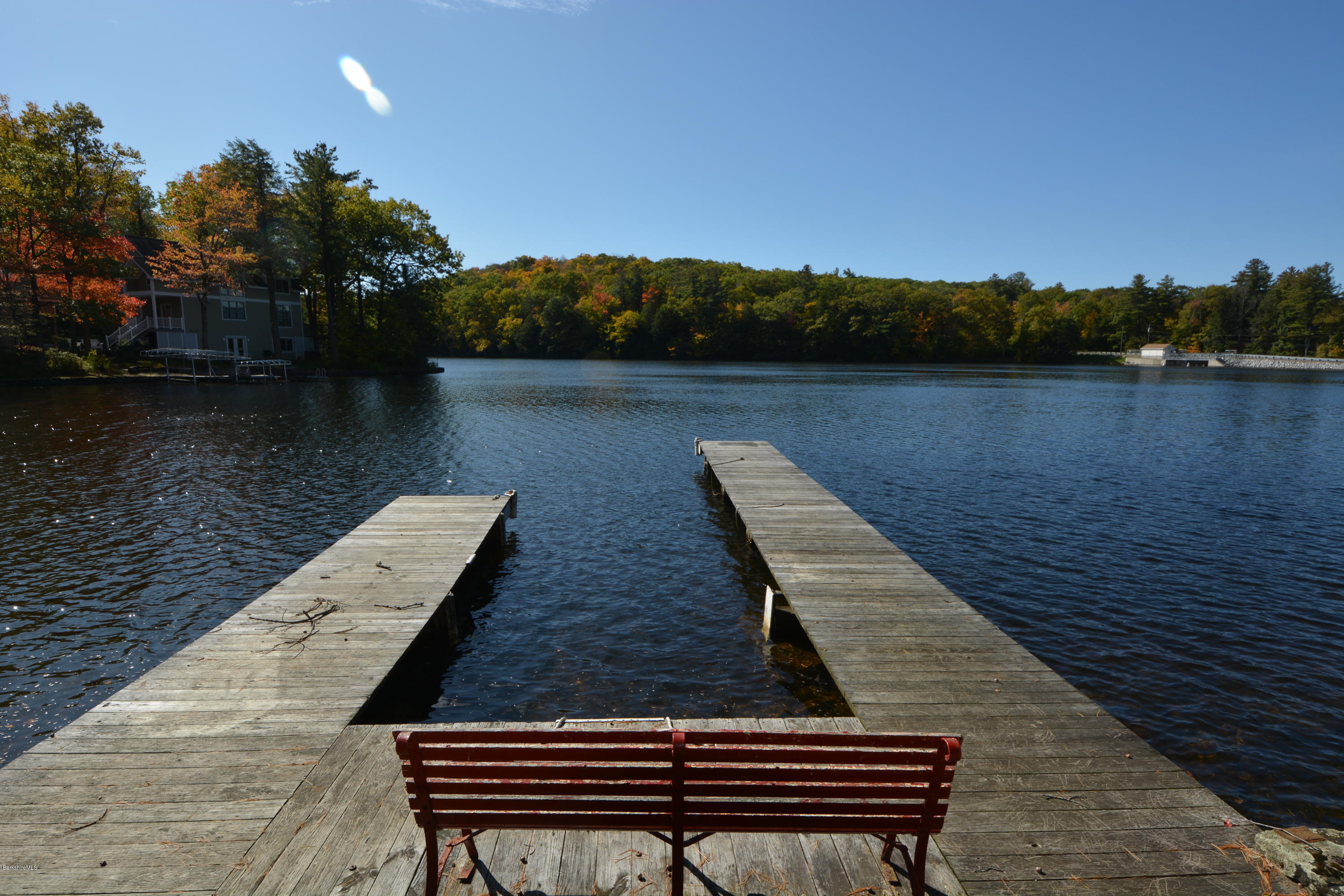 74 Kibbe Road Otis, MA 01029 - Photo 1 of 5 a wooden bench sitting next to a lake