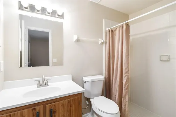 a bathroom with a sink a toilet a mirror and shower