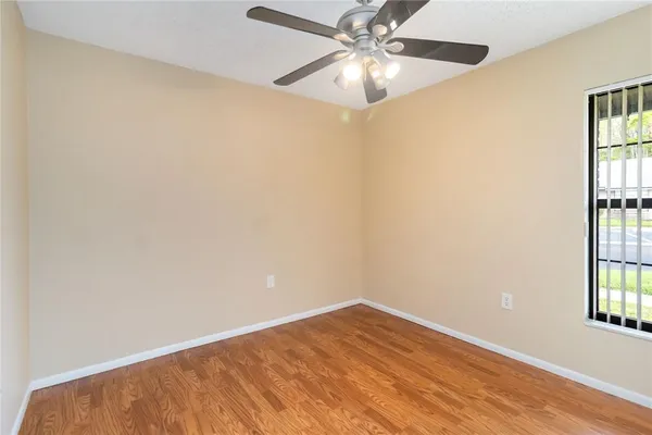 an empty room with windows and fan