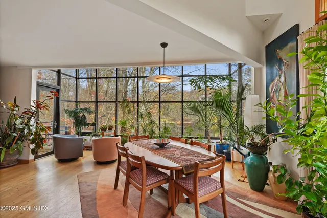 a dining room with furniture and a floor to ceiling window