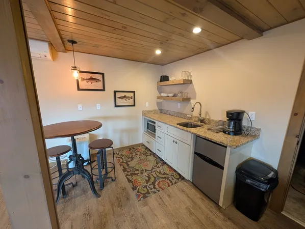 a kitchen that has a sink a stove and a table in it