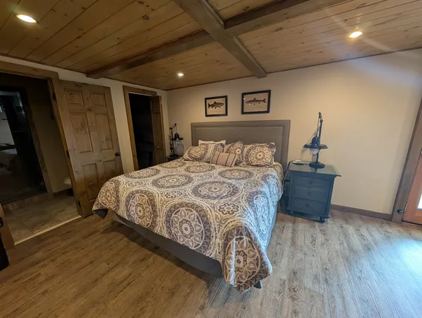 a bed sitting in a spacious bedroom next to a window