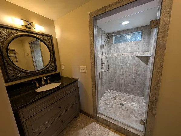 a bathroom with a granite countertop sink and a mirror