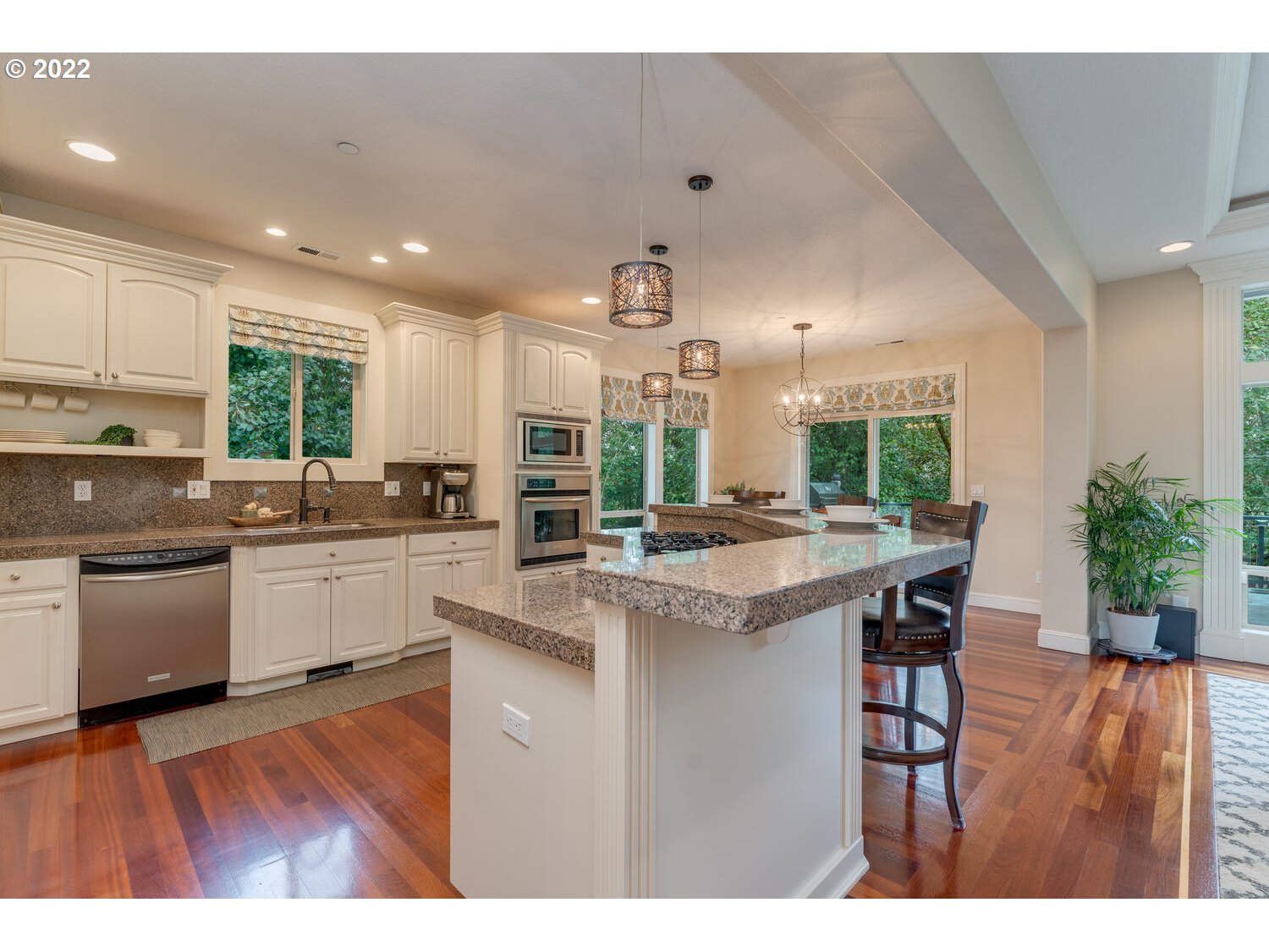 1337 Northwest Eagle Street Camas, WA 98607 - Photo 8 of 32 a kitchen with kitchen island granite countertop wooden floors and white cabinets