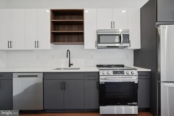 a kitchen with stainless steel appliances a stove a microwave and sink