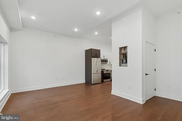 a view of a room with wooden floor and electronic appliances